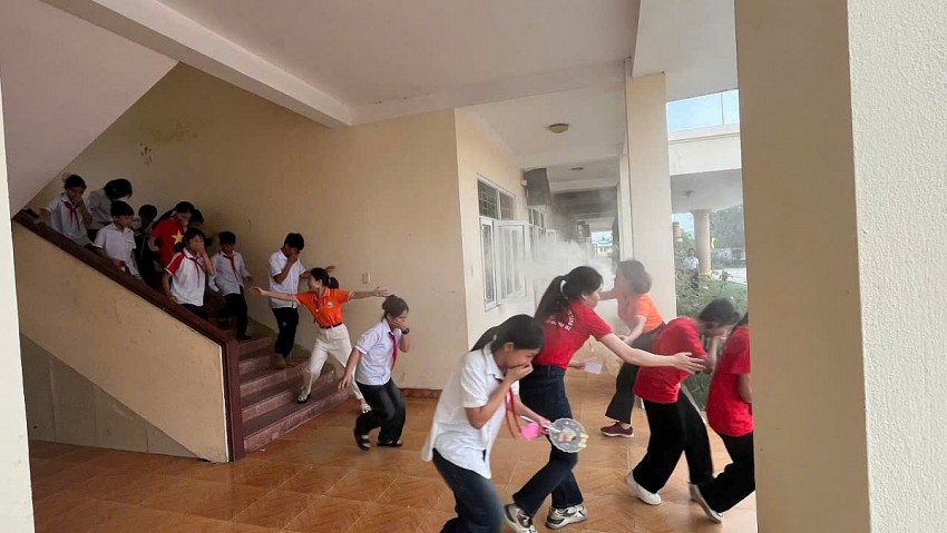 Cô giáo hướng dẫn học sinh thoát nạn.