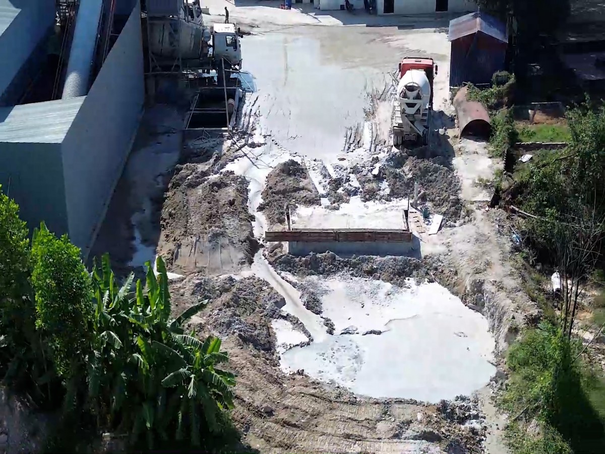 Cây cối quanh khu vực trạm trộn bê tông bị ảnh hưởng nghiêm trọng bởi bụi mịn và bùn thải từ quá trình rửa xe, trộn bê tông. Lớp bụi xi măng phủ lên lá và đất canh tác, làm giảm khả năng quang hợp và gây thoái hóa môi trường sinh thái địa phương. Ảnh: Đức Cường
