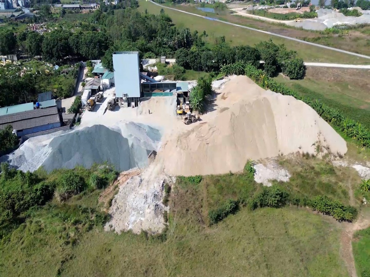 Hoạt động của trạm trộn bê tông tại phường Sơn Tây tạo ra bụi mịn từ quá trình tập kết, nghiền và bốc dỡ vật liệu. Lượng bụi phát tán theo gió bao phủ khu vực xung quanh, gây ô nhiễm không khí và ảnh hưởng trực tiếp đến cây trồng, thảm thực vật và đời sống người dân. Ảnh: Đức Cường